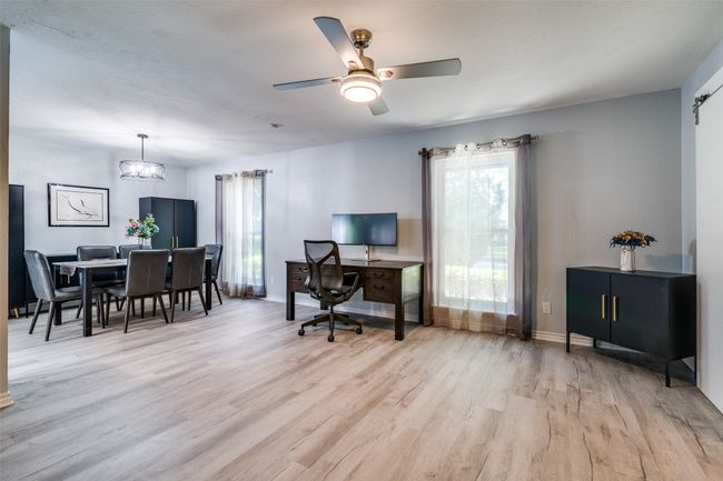 Home office featuring light wood-type flooring, baseboards, ceiling fan, and a chandelier | Image 8