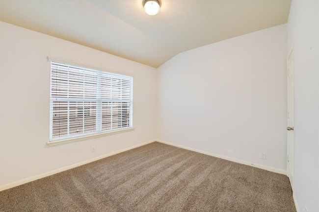 Carpeted empty room with vaulted ceiling and baseboards | Image 16