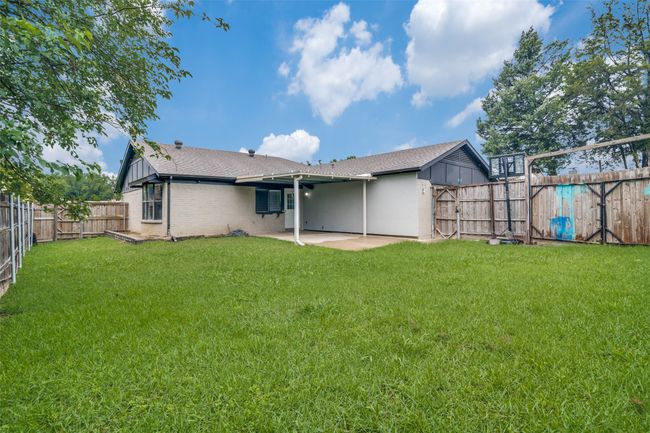 Back of property with a patio, a shingled roof, a fenced backyard, and brick siding | Image 25