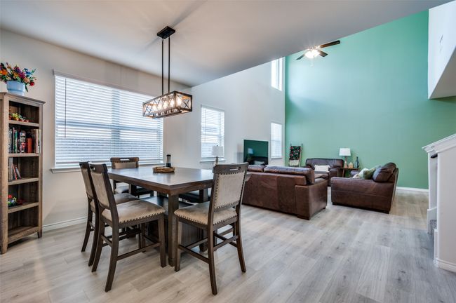 Dining room with baseboards, plenty of natural light, ceiling fan with notable chandelier, and light wood-type flooring | Image 7