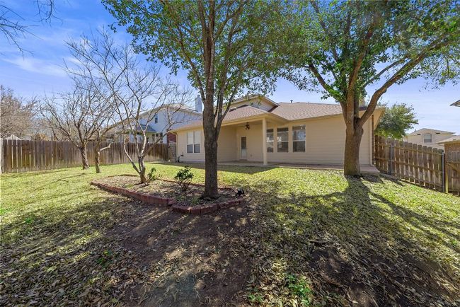 View of yard with ceiling fan, a fenced backyard, and a patio area | Image 22