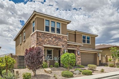 Stunning, stone & stucco facade, paver stone path, porch, steps and driveway. Home features dual artistic metal gates for rear yard access. | Image 2