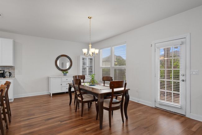 Dining space with a chandelier and dark wood finished floors | Image 13