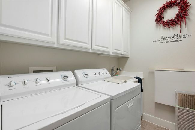 Laundry area featuring independent washer and dryer and cabinet space | Image 11