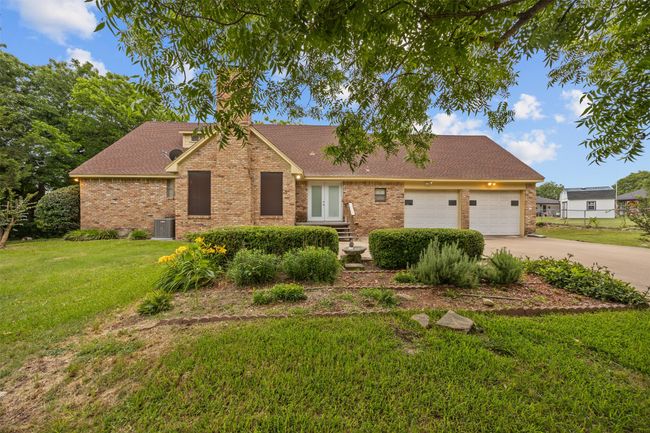 View of front facade featuring french doors, brick siding, concrete driveway, and an attached garage | Image 32