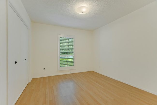 Spare room featuring light wood-type flooring, a textured ceiling, and baseboards | Image 14
