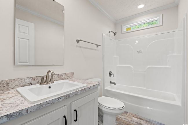 Full bath with toilet, crown molding, bathtub / shower combination, vanity, and wood finished floors | Image 25