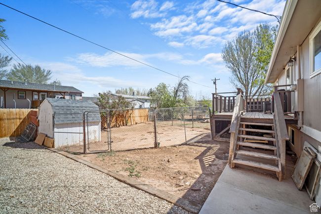 View of yard featuring a gate, a deck, a shed, and a fenced backyard | Image 23