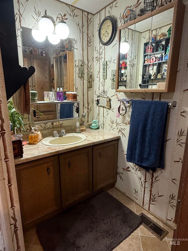Bathroom featuring tile patterned flooring, wallpapered walls, and vanity | Image 14
