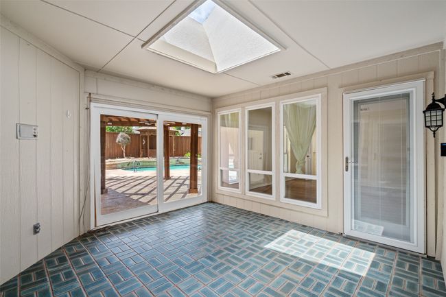 Unfurnished sunroom featuring a skylight and brick patterned flooring | Image 19
