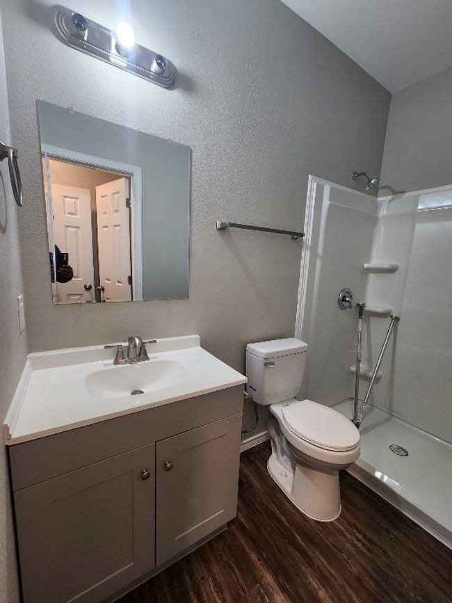 Full bath with wood finished floors, vanity, toilet, and a walk in shower | Image 12