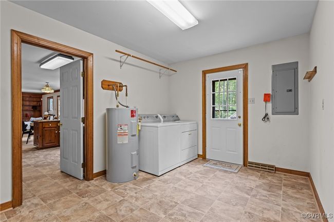 Washroom with electric panel, washer and dryer, and electric water heater | Image 17