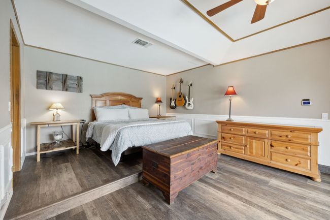 Primary Bedroom with Luxury Vinyl Plank Flooring, Platform, Wainscoting, and Recessed ceiling | Image 21