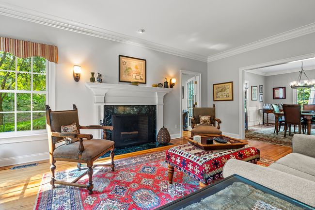 Elegant formal living room with fireplace that leads to the dining room. | Image 8