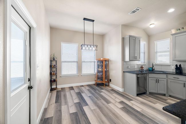 Kitchen with a sink, dark countertops, visible vents, gray cabinetry, and dishwasher | Image 10