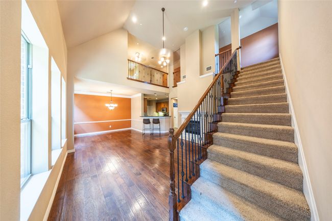 Stairway featuring high vaulted ceiling, a chandelier, and wood-type flooring | Image 5