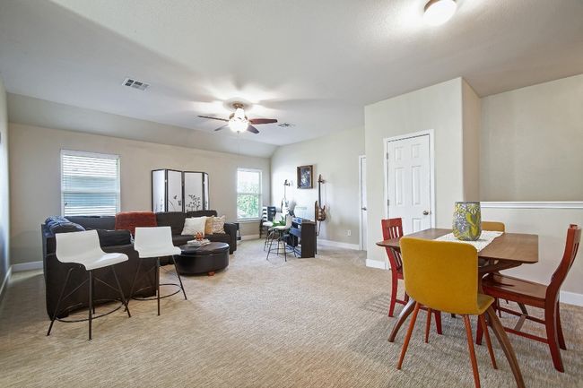 The upstairs den / bonus area features a ceiling fan, carpet flooring, and lots of space for fun, games, or relaxing. | Image 20