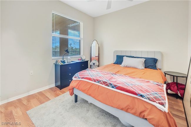 Bedroom with ceiling fan and light laminate wood flooring | Image 16