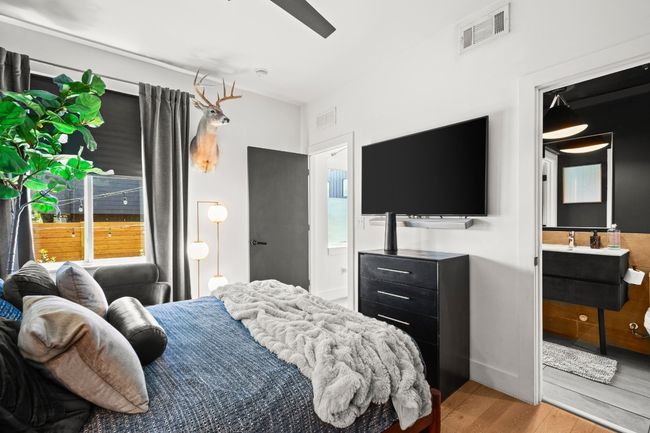 Bedroom with light wood finished floors and connected bathroom | Image 16