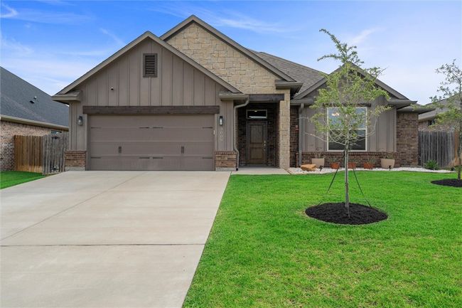 Craftsman inspired home with board and batten siding, driveway, an attached garage, and brick siding | Image 36
