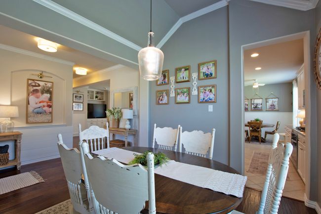 Dining area featuring crown molding, a ceiling fan, vaulted ceiling, and wood finished floors | Image 8