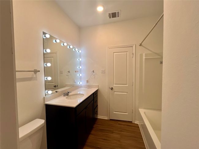 Bathroom with vanity, wood finished floors, and bathing tub / shower combination | Image 9