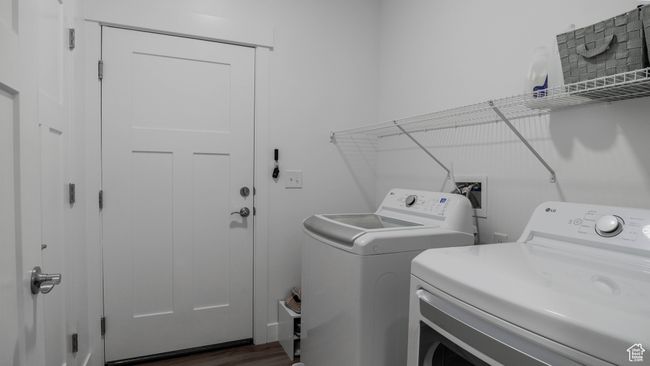 Washroom with dark wood-type flooring, washer and clothes dryer, and laundry area | Image 16