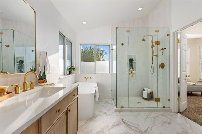 Bathroom with a shower stall, vanity, marble finish floor, lofted ceiling, and a freestanding bath | Image 25