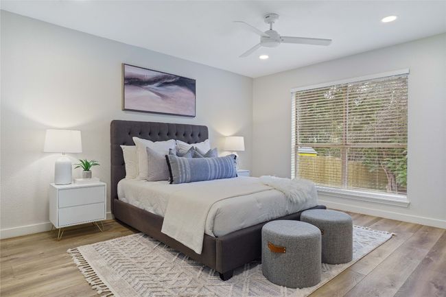 Bedroom featuring baseboards, light wood finished floors, and multiple windows | Image 21