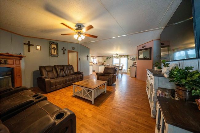 Living roomd, wood-style floors, ceiling fan, and a textured ceiling | Image 13