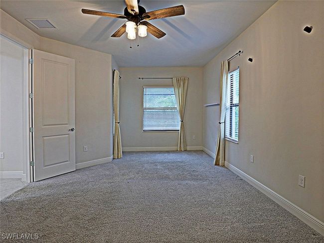 Unfurnished bedroom featuring carpet flooring, baseboards, and ceiling fan | Image 15