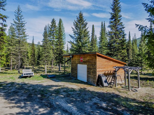 View of outbuilding with an outdoor structure, a view of trees, and driveway | Image 65