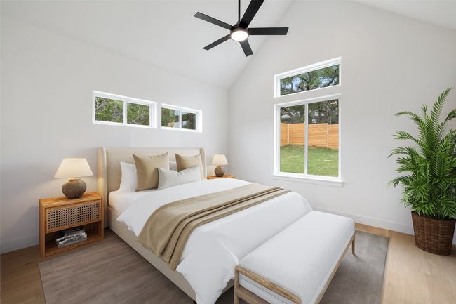 Bedroom with high vaulted ceiling, wood finished floors, baseboards, and ceiling fan | Image 15