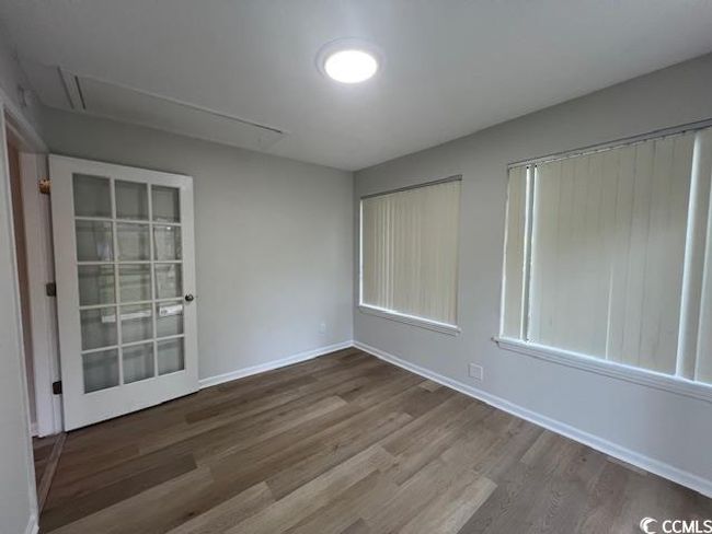 Spare room featuring baseboards, attic access, and wood finished floors | Image 34