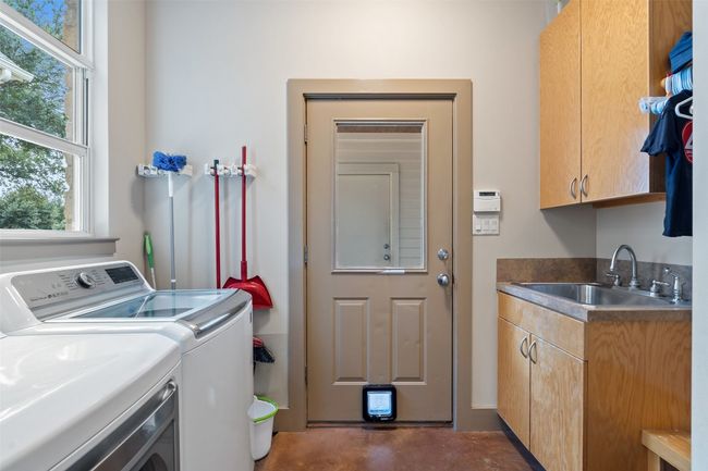 Laundry area featuring cabinet space and washing machine and clothes dryer | Image 30