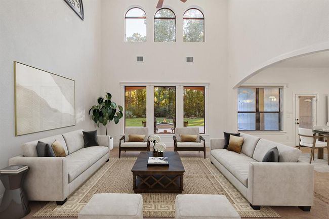 The spacious living room with high ceilings, large windows allowing for ample natural light, and a view of the outdoors. This picture is virtually staged. | Image 13