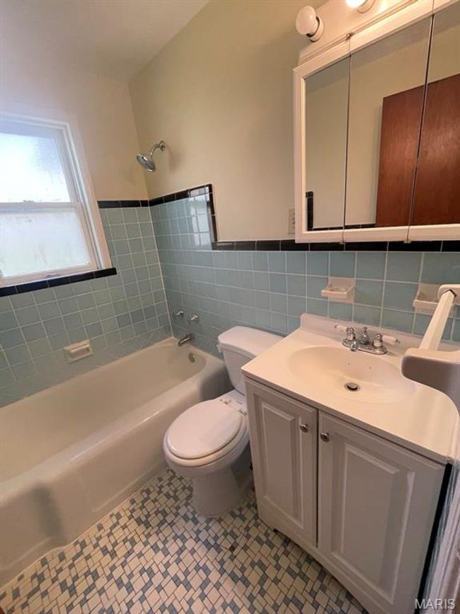 Full bath with wainscoting, vanity, tile walls, toilet, and shower / bathtub combination | Image 20
