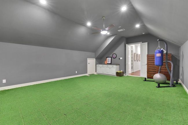 This dedicated media room offers versatility and is currently being used as a workout room. Its scale and features make it a state-of-the-art media room - as the space boasts a striking gable ceiling, creating an open and airy feel, while built-in surround sound wiring sets the stage for a truly theater-like entertainment experience. | Image 37