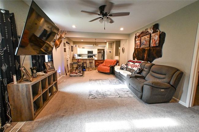 Carpeted living room featuring ceiling fan and baseboards | Image 21