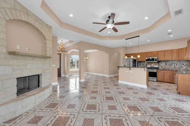 Kitchen with a raised ceiling, arched walkways, tasteful backsplash, open floor plan, and a chandelier | Image 9