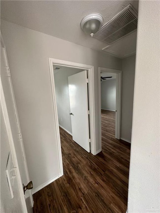 Hallway featuring visible vents, dark wood-type flooring, and baseboards | Image 14