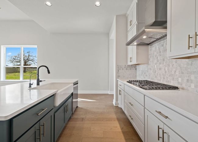 Kitchen featuring recessed lighting, a sink, stainless steel appliances, wall chimney exhaust hood, and baseboards | Image 15