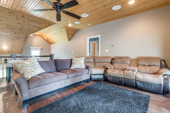 Living room featuring wooden ceiling, ceiling fan, vaulted ceiling, and hardwood / wood-style floors | Image 26