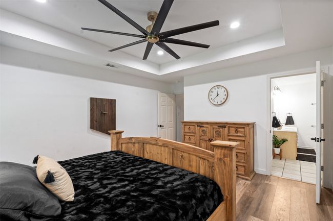 Bedroom featuring hardwood / wood-style flooring, ceiling fan, and a raised ceiling | Image 13