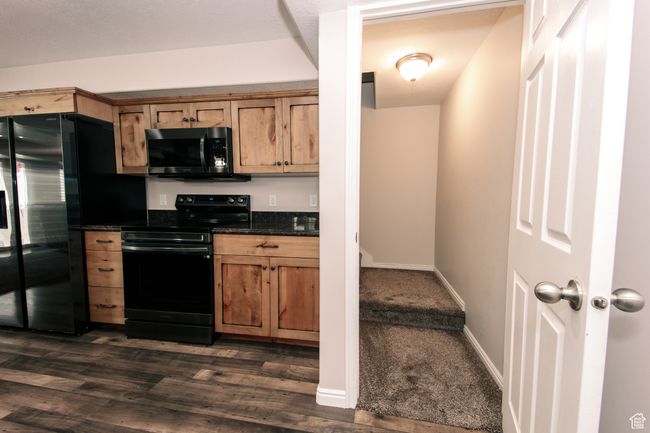 ADU - The kitchen features LVP flooring, dark countertops, baseboards, and black appliances. The entrance from the main level is featured on the right. | Image 22