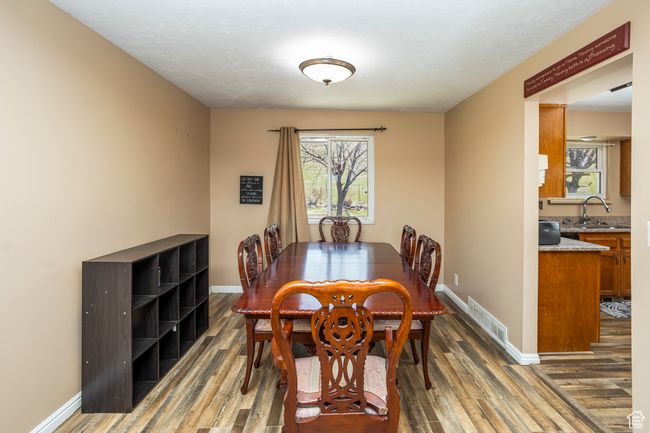 Dining room featuring baseboards, visible vents, and wood finished floors | Image 9
