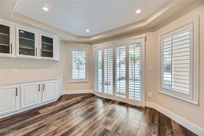 Unfurnished dining area featuring a raised ceiling, dark wood-style floors, plenty of natural light, and recessed lighting | Image 15