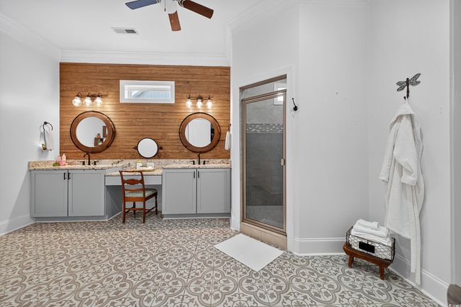 Bathroom with double vanity, a ceiling fan, a shower stall, and crown molding | Image 24