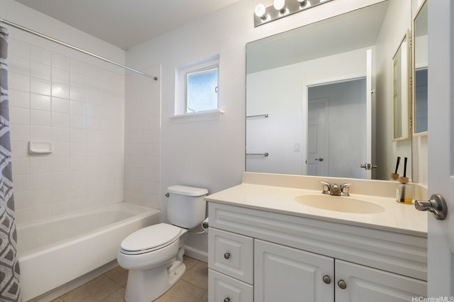 The hallway bathroom features another bathtub & shower. | Image 19