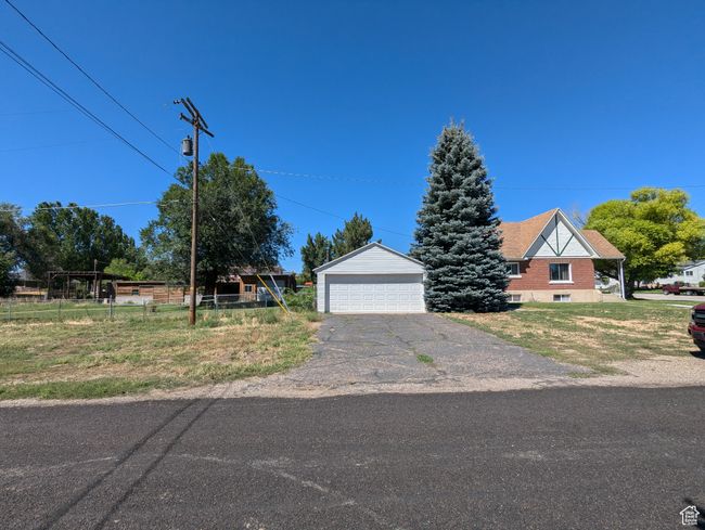 View of front of home with an outbuilding, fence, and a garage | Image 45